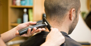a hair stylist is trimming the hair of a man